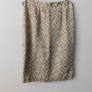 May include: A brown and white patterned skirt with a straight silhouette. The skirt is made of a woven fabric and has a subtle sheen.