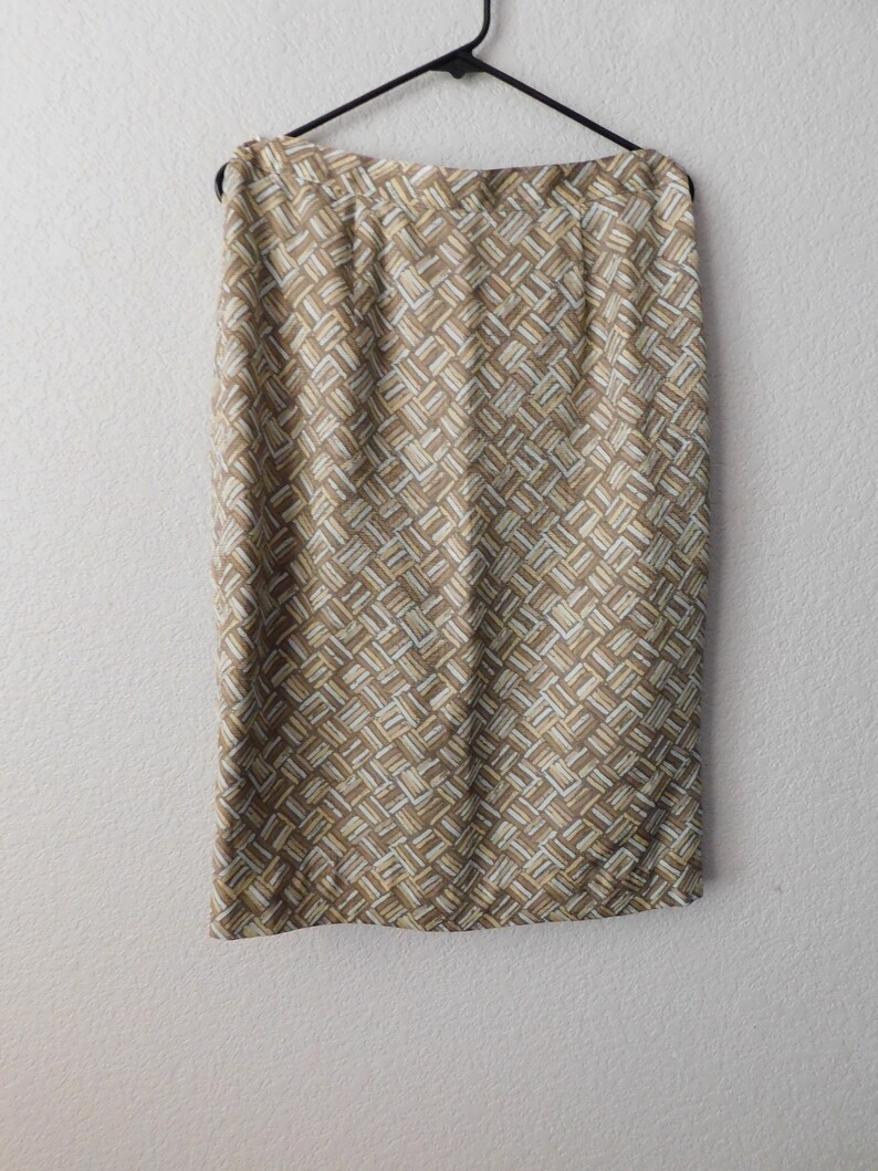 May include: A brown and white patterned skirt with a straight silhouette. The skirt is made of a woven fabric and has a subtle sheen.