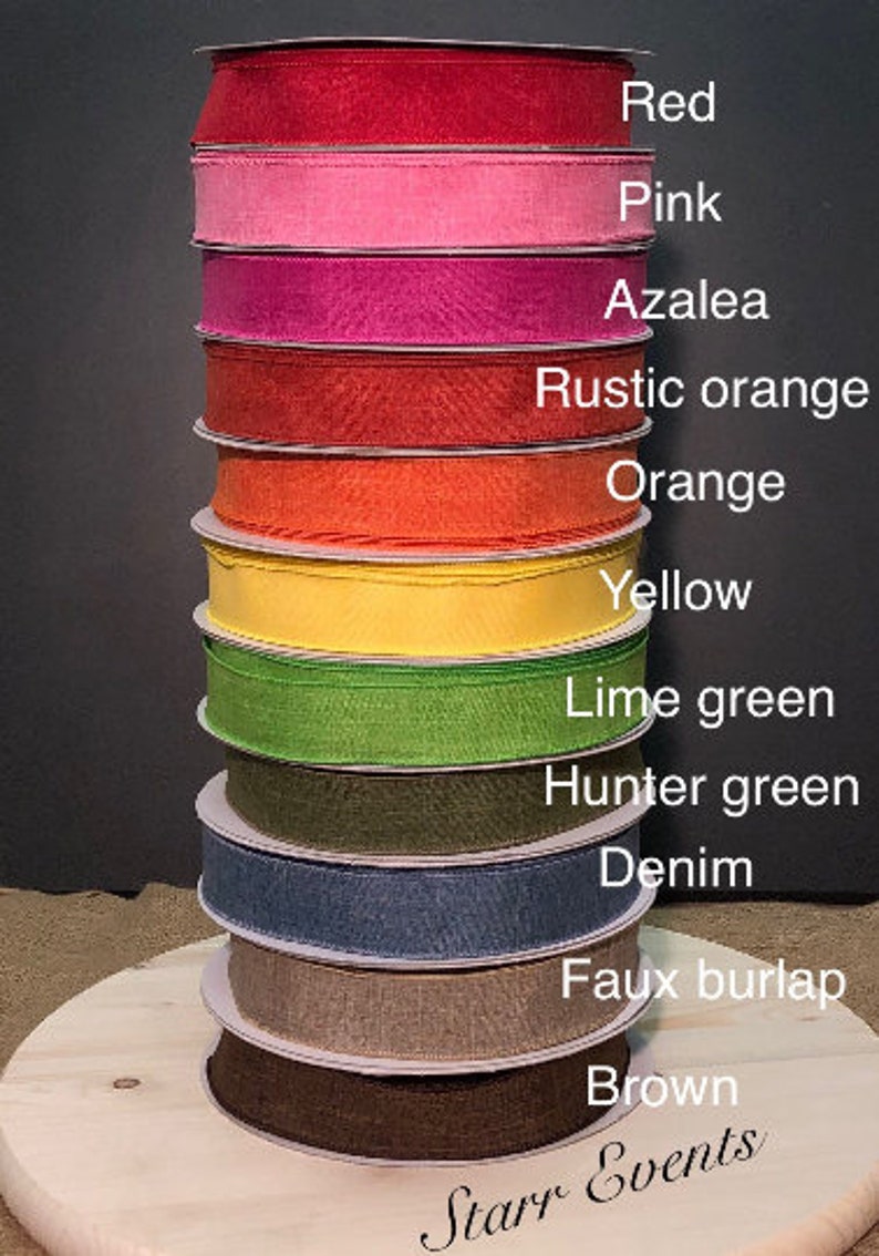 May include: A stack of 11 different colored ribbon spools, each with a label indicating its color. The colors are red, pink, azalea, rustic orange, orange, yellow, lime green, hunter green, denim, faux burlap, and brown. The bottom spool is brown and the top spool is red. The label at the bottom of the stack reads "Starr Events".