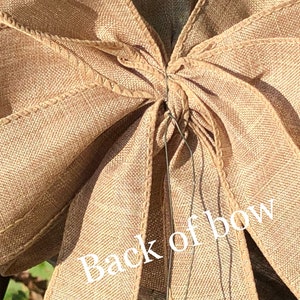 May include: A close-up of the back of a brown burlap bow tied with wire. The text "Back of bow" is visible in the image.