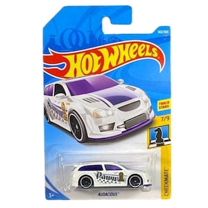 May include: A white Hot Wheels die-cast car with purple accents and black wheels. The car features a chess-themed design with the word "Pawn" and a chess piece graphic. The packaging is blue with the Hot Wheels logo and the text "Track Stars".