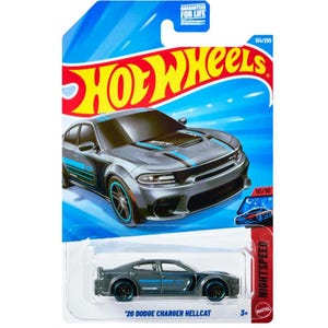 May include: A Hot Wheels die-cast toy car on a blue and red card. The car is a gray Dodge Charger Hellcat with blue racing stripes and accents. The card features the Hot Wheels logo and the text "NIGHTSPEED".