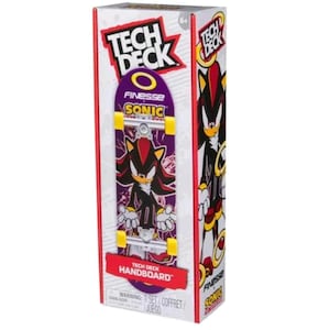 May include: A Tech Deck handboard featuring a purple and black design with the character Shadow from Sonic. The handboard has yellow wheels and the Tech Deck logo is visible on the packaging.