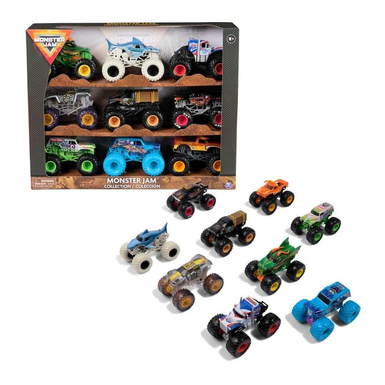 May include: A collection of toy monster trucks in a display box and scattered around it. The trucks are various colors, including green, blue, and orange, with large tires. The box has the text "MONSTER JAM COLLECTION / COLECCI&Oacute;N".