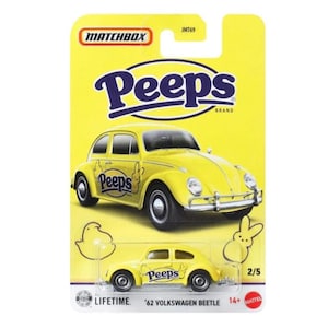 May include: A yellow Matchbox die-cast toy car of a '62 Volkswagen Beetle, branded with the Peeps logo. The packaging is yellow with the Matchbox and Peeps logos. The car is a 2/5 model and is suitable for ages 14+.