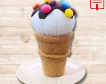 May include: A felt ice cream cone with white ice cream, chocolate sauce, and colorful sprinkles. The ice cream cone is sitting on a white plate.  ©Felt_Kreations