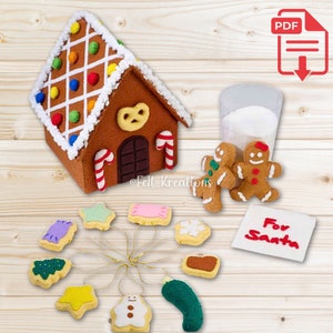 May include: Felt gingerbread house with candy decorations, two gingerbread people, a glass of milk, and a variety of felt cookies, including a star, a snowflake, a tree, a snowman, and a pickle. The cookies are attached to gold strings. A white note reads "For Santa".