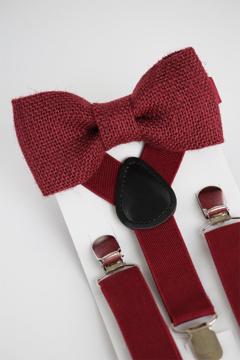 May include: A burgundy bow tie made of burlap fabric and matching burgundy braces with silver clips and a black leather adjustable strap.