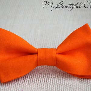 May include: A bright orange bow tie made of fabric.