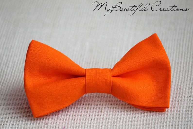 May include: A bright orange bow tie made of fabric.