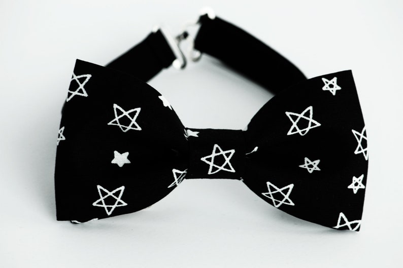 May include: A black bow tie with a white star pattern. The stars are drawn in a simple, hand-drawn style.