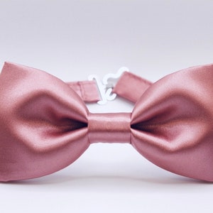May include: A dusty rose satin bow tie. The bow tie is tied and ready to wear.