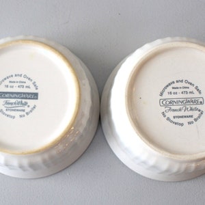 May include: Two white stoneware bowls with textured sides. The bowls are marked "French White" and "16 oz - 473 ml". The bowls are microwave and oven safe. The bowls are made in China.