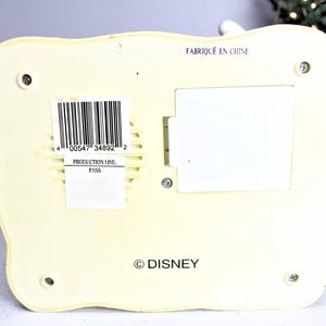 May include: A white plastic figurine with a barcode and the text "00547" 34892" 2, "Production Line: Pass", "FABRIQU&Eacute; EN CHINE", and "&copy; DISNEY".