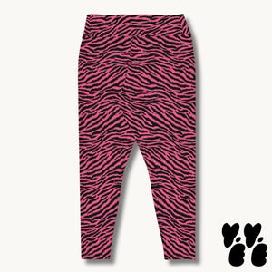 May include: High-waisted leggings featuring a vibrant hot pink and black zebra stripe pattern. The garment has a fitted silhouette with a wide waistband and tapered legs that extend down to the ankles, showcasing a bold animal print design.