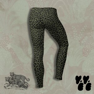 May include: Full-length leggings featuring a dark olive green base color with a repeating black leopard print pattern. The garment has a fitted silhouette with a high waistband and tapered legs that extend down to the ankles.