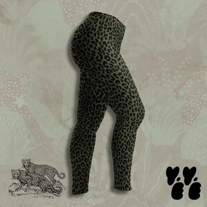 May include: Leggings featuring an olive green base color with a repeating black leopard print pattern. The garment has a high-waisted design and full-length legs that taper toward the ankles, showcasing a consistent animal-inspired graphic.
