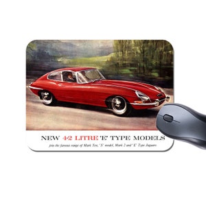 May include: A red 1960s Jaguar E-Type sports car driving on a winding road. The car is a 4.2 litre model. The text on the image reads "NEW 4.2 LITRE 'E' TYPE MODELS join the famous range of Mark Ten, 'S' model, Mark 2 and 'E' Type Jaguars".