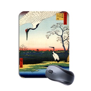Peut inclure: Un tapis de souris avec une estampe japonaise sur bois de deux grues dans un paysage. L'estampe est dans des tons de bleu, vert, rouge et blanc. Le texte sur l'estampe est "三谷梅香"