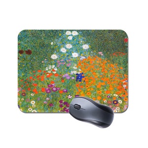 Op de afbeelding: Een kleurrijk muismat met een schilderij van een bloemenveld in verschillende tinten oranje, geel, paars, wit en groen.