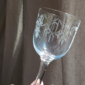May include: A clear glass stemmed shot glass with an etched design of bamboo leaves.