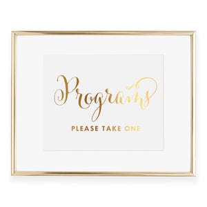May include: Gold framed sign with the text "Programs" in gold script lettering and the text "Please Take One" in smaller gold lettering.