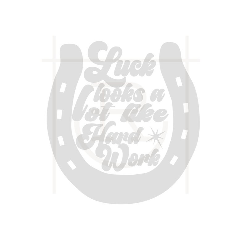 May include: A light gray horseshoe design with the text "Luck looks a lot like Hard Work" in a stylized font. A star graphic is included in the design. The image is on a white background.