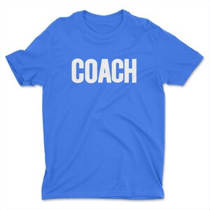 K&ouml;nnte beinhalten: Ein hellblaues T-Shirt mit dem Wort "COACH" in wei&szlig; auf der Vorderseite.