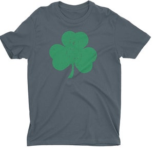 Pode incluir: Uma camiseta azul escura com um gr&aacute;fico de trevo verde. O trevo tem um visual desgastado e vintage.