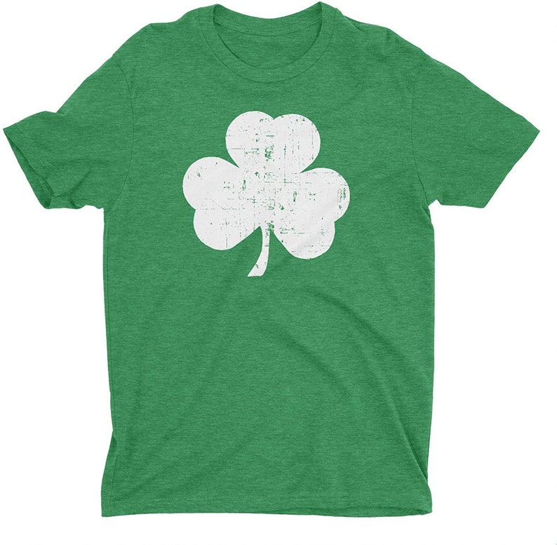 Pode incluir: Uma camiseta verde com um design de trevo branco desbotado.