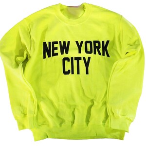 May include: A bright yellow sweatshirt with black text that reads "NEW YORK CITY".