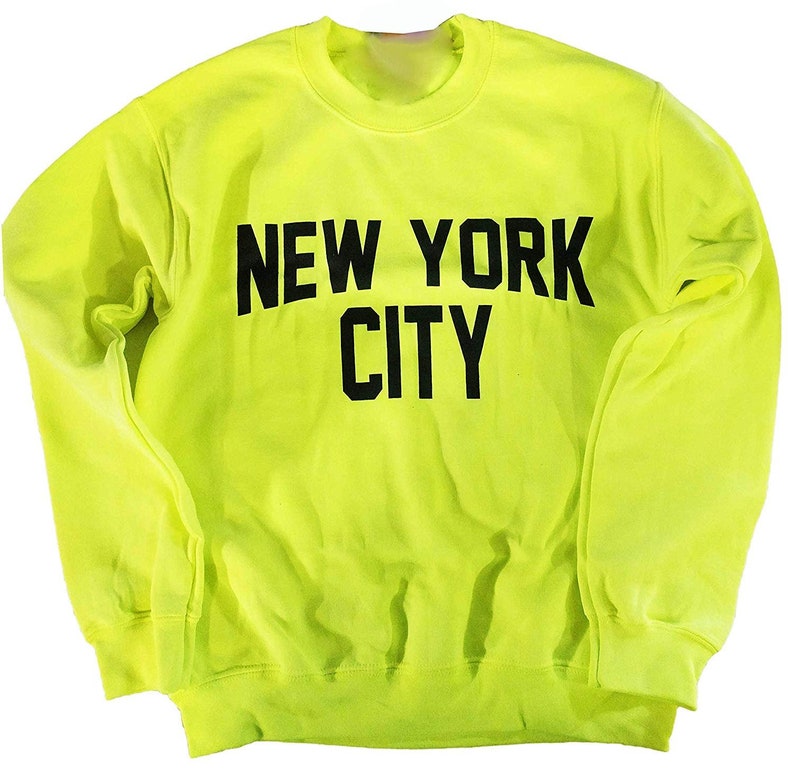 May include: A bright yellow sweatshirt with black text that reads "NEW YORK CITY".