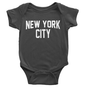 May include: A dark gray baby onesie with white text that reads "NEW YORK CITY".