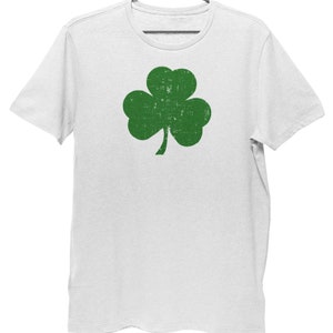 Pode incluir: Camiseta branca com um gr&aacute;fico de trevo verde. O trevo tem um visual desgastado e vintage.