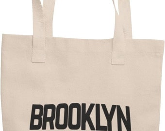 May include: A beige canvas tote bag with black handles and the text "BROOKLYN NEW YORK" printed on the front.