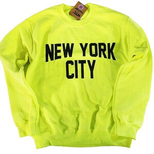 May include: A neon yellow sweatshirt with black text that reads "NEW YORK CITY".
