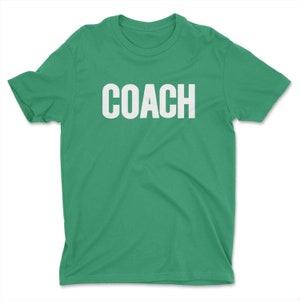 K&ouml;nnte beinhalten: Ein gr&uuml;nes T-Shirt mit dem Wort "COACH" in wei&szlig; auf der Vorderseite.