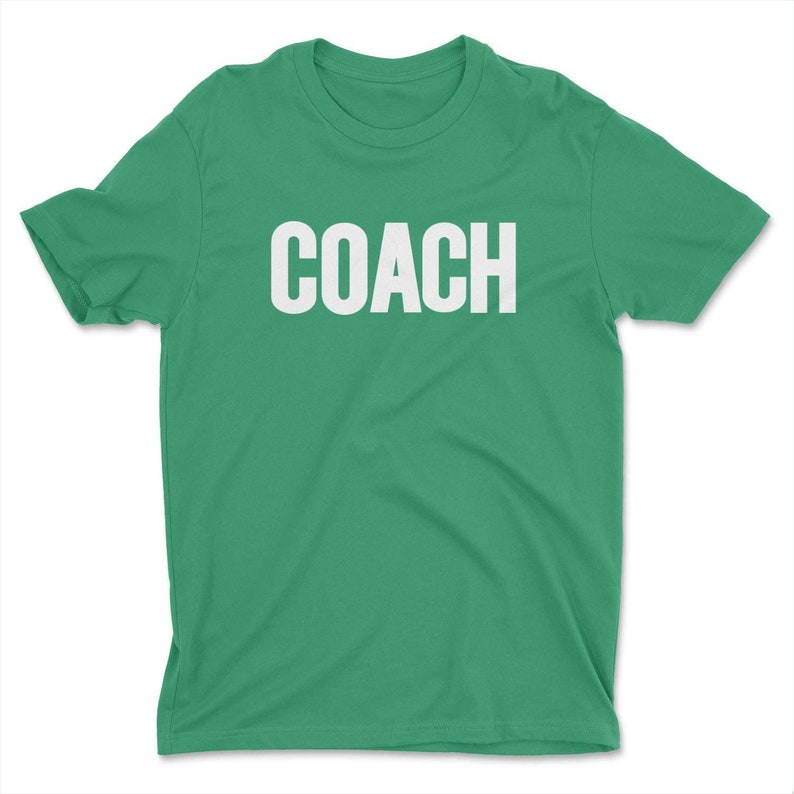 K&ouml;nnte beinhalten: Ein gr&uuml;nes T-Shirt mit dem Wort "COACH" in wei&szlig; auf der Vorderseite.