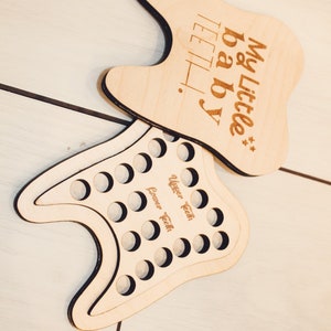 May include: Wooden tooth-shaped box with the text "My Little baby teeth" engraved on the top. The box has 12 circular cutouts for storing baby teeth, labelled "Lower Teeth" and "Upper Teeth".