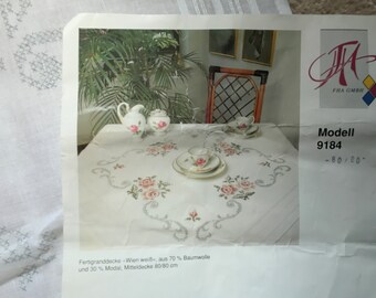 Printed tablecloth kit ( cross stitch) . Roses in shades of pink with greenery. 80 x 80 cm square. Threads included. Preowned