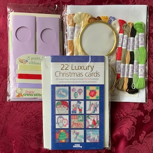 Puede incluir: Un kit de punto de cruz con diseños de tarjetas navideñas, hilo de bordar, un marco redondo y cintas. El kit incluye 22 tarjetas navideñas de lujo con diseños para coser y enviar. El kit también incluye el texto "Enjoy cross stitc".