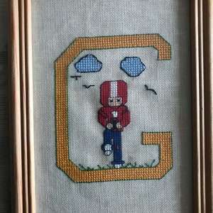 Cross stitched pictures, framed, letter G. Ideal for a child bedroom. Three options to choose from, fishing, basketball or American football