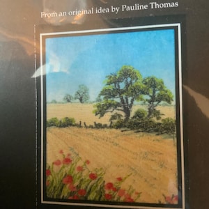 May include: A framed needlepoint picture of a rural landscape with a field of wheat, a large tree, and red poppies in the foreground. The text "Harvest in August." is printed below the image.
