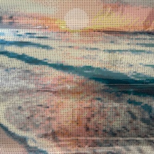 Puede incluir: Primer plano de una pintura de diamantes en proceso, que muestra una escena de agua azul y blanca con una puesta de sol amarilla y naranja en el fondo.