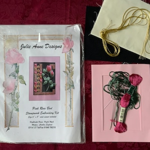 Pode incluir: Um kit de bordado Stampwork Pink Rose Bud da Julie Anne Designs. O kit inclui um cartão rosa, linha de bordar, agulhas e tecido. A embalagem apresenta uma imagem emoldurada em rosa de uma rosa. O kit tem 15,24 cm x 20,32 cm.