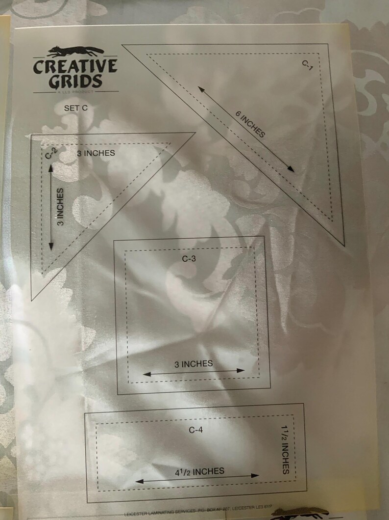 以下が含まれることがあります： 半透明の背景に4つの形状の黒い輪郭が描かれたCreative Grids Set Cテンプレートシート。形状には、C-1とラベル付けされた15.24cmの三角形、C-2とラベル付けされた7.62cmの三角形、C-3とラベル付けされた7.62cmの正方形、およびC-4とラベル付けされた11.43cm x 3.81cmの長方形が含まれています。