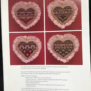 Può includere: Uno schema di ricamo a punto croce per un ornamento a forma di cuore con uno schema di colori rosa e marrone. Il motivo include il testo "Noel Noel" ed è circondato da un bordo di pizzo bianco. Il modello è di Mill Hill Publications.