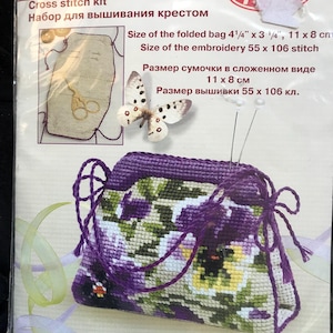 May include: Cross stitch kit featuring a purple and yellow floral design. The kit includes pre-printed fabric, embroidery floss, and needles. The finished project is a small bag measuring 4 1/4 inches by 3 1/4 inches. The kit is labelled "RIOLIS" and "Сотвори Сама 1039".