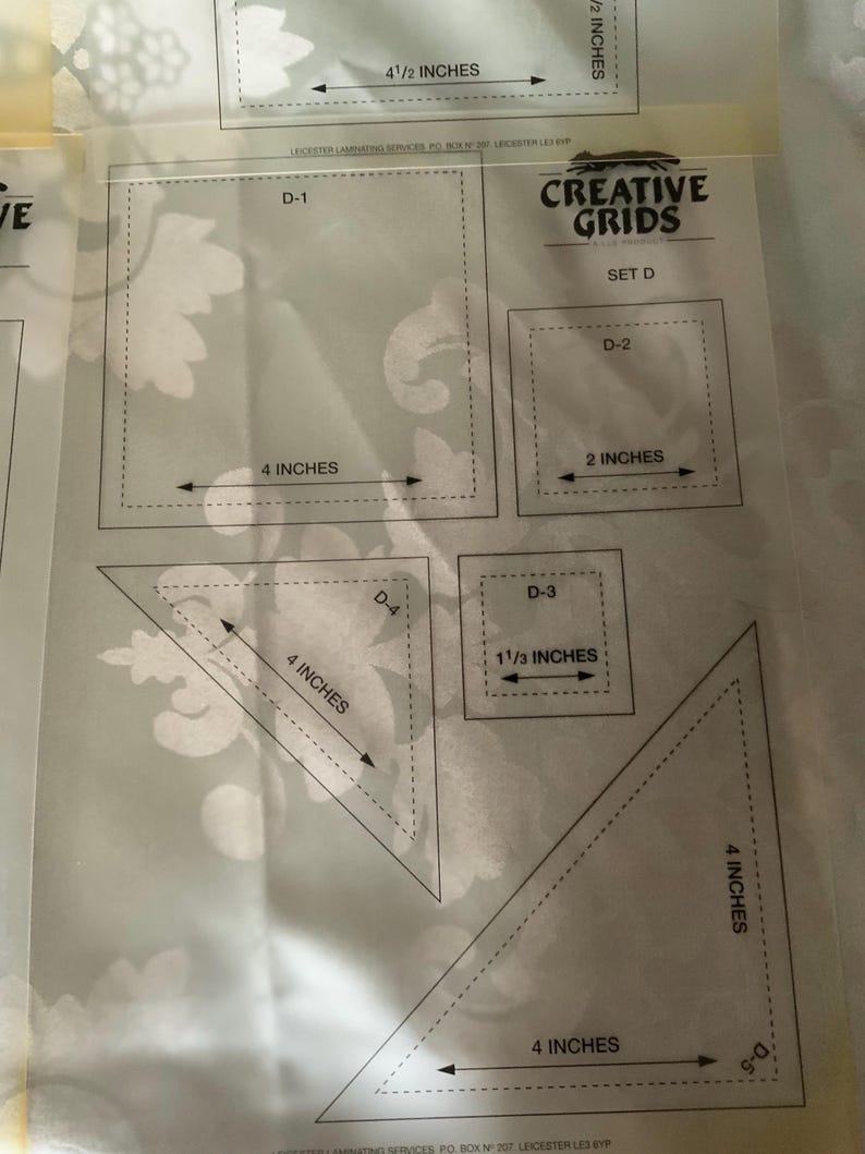 以下が含まれることがあります： インチ単位の寸法が印刷されたCreative Grids Set Dの透明なプラスチック製キルティングテンプレートシート。D-1からD-5までのラベルが付いた様々な形状が含まれており、4インチの長方形、2インチの正方形、1 1/3インチの正方形、および2つの4インチの三角形で構成されています。