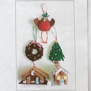 May include: Five felt Christmas decorations: a robin, a wreath, a Christmas tree, a gingerbread house, and a nativity scene. The decorations are all handmade and feature intricate details. The image is from Daisy Chain Designs and is titled "Tree Trinkets by G Penberthy".